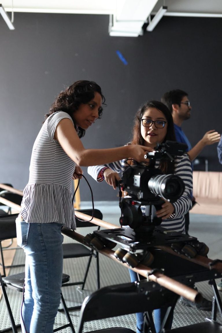 Dvoje filmskih stvaralaca podešava kameru na stativu